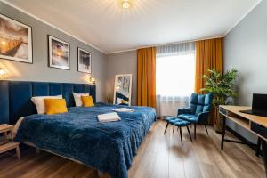 una camera d'albergo con un letto blu e una scrivania di Maloves Resort & Spa, pokoje w bocznych budynkach a Władysławowo