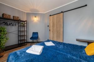 una camera con un letto blu e una sedia blu di Maloves Resort & Spa, pokoje w bocznych budynkach a Władysławowo