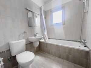 a bathroom with a toilet and a sink and a tub at Pernera Seaside Villa - Sun, Sea, Poolside Bliss in Protaras +6 photos