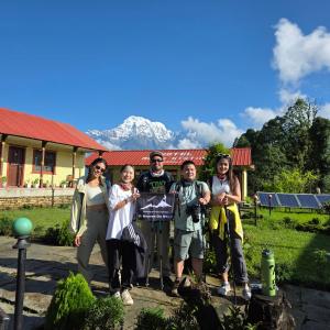 un grupo de personas posando para una foto con montañas en el fondo en Hotel mardi station, en Astam 11 fotos más