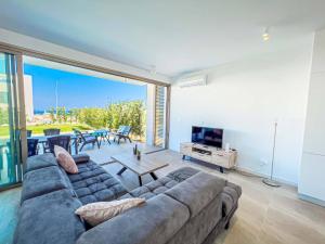 a large living room with a couch and a tv at Azure Villas by Marc in Paralimni