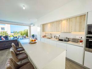 a kitchen with a table and chairs and a couch at Azure Villas by Marc in Paralimni