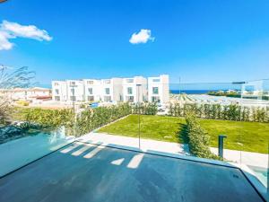 a swimming pool in front of a white building at Azure Villas by Marc in Paralimni