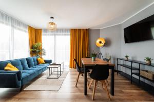 un soggiorno con un divano blu e un tavolo di Maloves Resort & Spa, pokoje w bocznych budynkach a Władysławowo