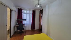 ein Schlafzimmer mit einem gelben Bett und einem Schreibtisch in der Unterkunft Osvalley Résidence in Basse-Terre