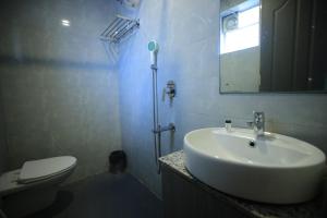 ein Badezimmer mit Waschbecken, Toilette und Spiegel in der Unterkunft Hillside Aqua in Bhubaneshwar + 7 Fotos