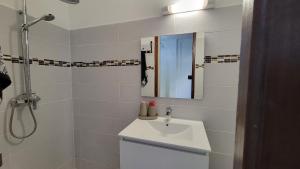 ein weißes Badezimmer mit Waschbecken und Spiegel in der Unterkunft Osvalley Résidence in Basse-Terre