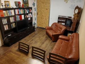 een woonkamer met lederen meubels en een televisie bij Laajavuoren majapaikka — Condo in Laajavuori in Jyväskylä