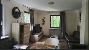 un soggiorno con un divano e una TV di Ferienhaus Lemmerwald a Neerdar