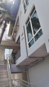 une maison blanche avec des escaliers et un palmier dans l'établissement JR Residence, à Kota Kinabalu