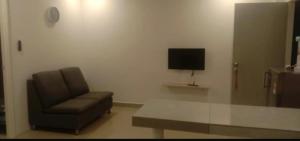 a living room with a chair and a television at JR Residence in Kota Kinabalu