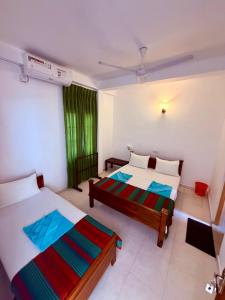 恩比利皮蒂耶Vishmee Holiday Inn的有两张床和一扇窗户的卧室