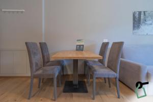 a wooden table with chairs and a table with a clock on it at HOTIDAY Bormio Apartments in Bormio