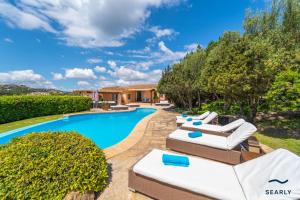 a villa with a swimming pool with lounge chairs at Villa Il Varo - By Searly in Liscia di Vacca
