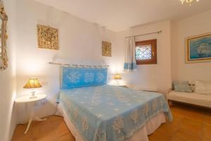 a bedroom with a blue bed and a couch at Villa Il Varo - By Searly in Liscia di Vacca +107 photos