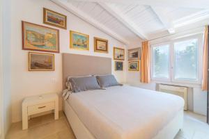 een slaapkamer met een groot wit bed en een raam bij Villa Alfa - By Searly in Porto Rotondo