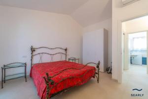 ブドーニにあるCasa Mirella - By Searlyの赤い掛け布団が敷かれたベッドのある寝室