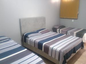 una camera con 3 letti di Apto Confortável e espaçoso 02 a Cachoeira do Sul