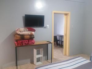 Camera con TV e tavolo con letto di Apto Confortável e espaçoso 02 a Cachoeira do Sul