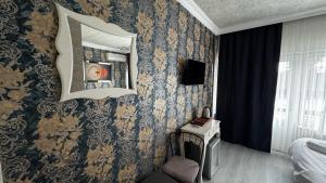a bedroom with blue and gold wallpaper and a mirror at Tuzla Sahil Enjoy Hotel in Tuzla