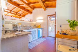 a large kitchen with a counter top and a counter top at Villa San Teodoro - By Searly in Punta Molara