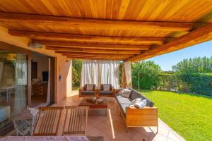 a living room with a wooden pergola at Villa Molara Home - By Searly in Punta Molara
