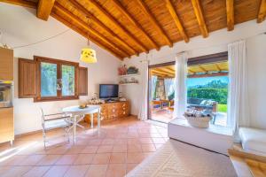 a kitchen with a table and a dining room at Villa Molara Home - By Searly in Punta Molara