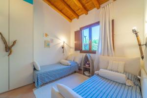 a bedroom with two beds and a window at Villa Molara Home - By Searly in Punta Molara