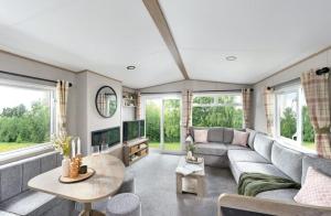 ein Wohnzimmer mit Sofa und Tisch in der Unterkunft Ruda Holiday Park in Croyde