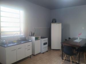 a kitchen with a sink and a refrigerator and a table at Apto Confortável e espaçoso 02 in Cachoeira do Sul