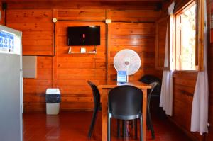 a dining room with a table and chairs and a tv at Gosén Cabañas Sanagasta in Villa Bustos