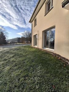 ein Haus mit einem Rasenhof neben einem Gebäude in der Unterkunft La Marceline, maison proche du village in Charavines + 12 Fotos