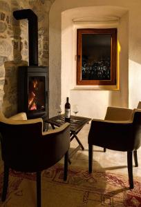 ein Wohnzimmer mit Kamin, Tisch und Stühlen in der Unterkunft Historic Waterfront House in Muo