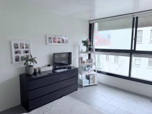 sala de estar con TV y ventana grande en Potts Point Cozy Studio Near Parks Water, en Sídney