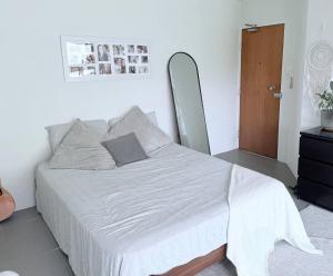 Una cama blanca en una habitación con espejo. en Potts Point Cozy Studio Near Parks Water, en Sídney