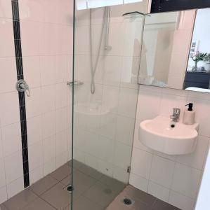 un baño con ducha y lavabo en Potts Point Cozy Studio Near Parks Water, en Sídney