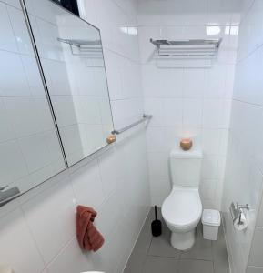 Un baño blanco con inodoro y ducha. en Potts Point Cozy Studio Near Parks Water, en Sídney 8 fotos más