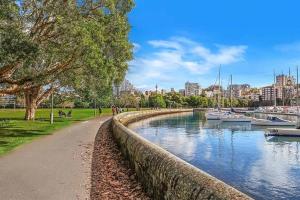 un camino junto a un cuerpo de agua con barcos en Potts Point Cozy Studio Near Parks Water, en Sídney