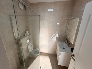 ein Badezimmer mit Dusche, Toilette und Waschbecken in der Unterkunft Staywell University with underground parking in Suceava