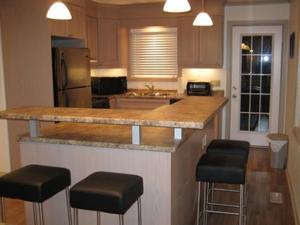 杰克逊JACKSON HIDEAWAY的厨房配有带凳子的柜台和冰箱