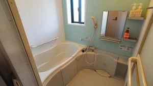 a small bathroom with a tub and a sink at 佐世保まち宿 in Sasebo +18 photos