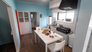 a small kitchen with a white table and a stove at 佐世保まち宿 in Sasebo