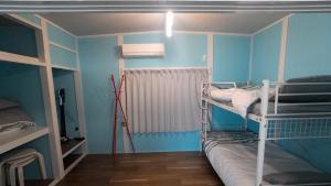 a bunk bed in a room with blue walls at 佐世保まち宿 in Sasebo
