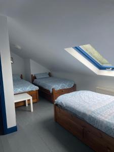 a bedroom with two beds and a skylight at The Old Coastguard Lodge in Dingle