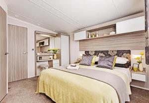 ein Schlafzimmer mit einem großen Bett mit einer gelben Decke in der Unterkunft Ruda Holiday Park in Croyde + 129 Fotos