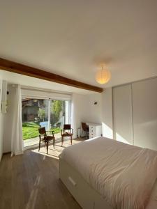 een slaapkamer met een bed en een raam met stoelen bij La Pilote in Ponlat-Taillebourg +32 foto's