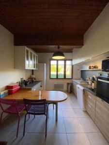 een keuken met een houten tafel en 2 stoelen bij La Pilote in Ponlat-Taillebourg