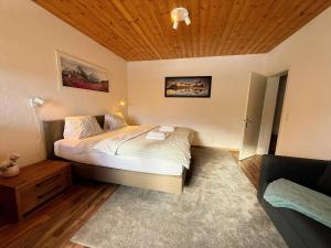 a bedroom with a bed and a wooden ceiling at Miraflor Sonja by Arosa Holiday in Arosa +6 photos