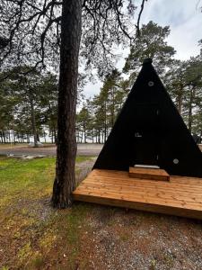 a black tent sitting next to a tree at Forest View Cottage 