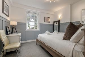 a bedroom with a bed and a chair and a window at Kincaple Garden Flat - Kincaple in Guard Bridge